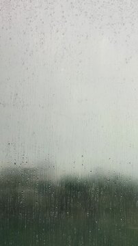 Rainy Day Window View with Water Drops Sliding Down Glass