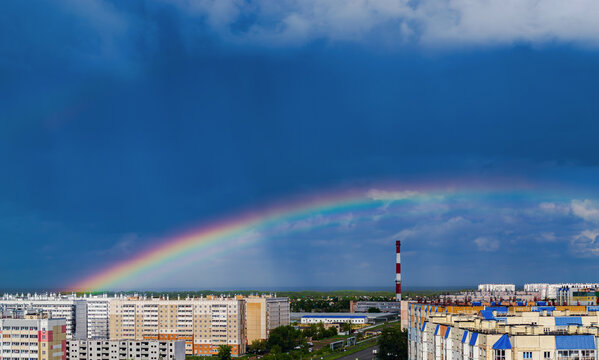 Fantastic beautiful rainbow over city buildings after rain