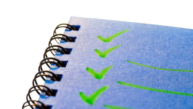 Isolated spiral notebook with green checklist marks for tasks and goals completed.