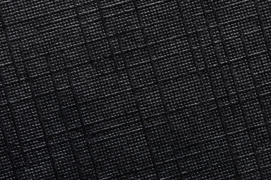 Macro Close-up of Black Ripstop Fabric Texture with Grid Pattern,High-detail macro shot of a durable black ripstop nylon material, showcasing the reinforced square grid weave and technical fiber.