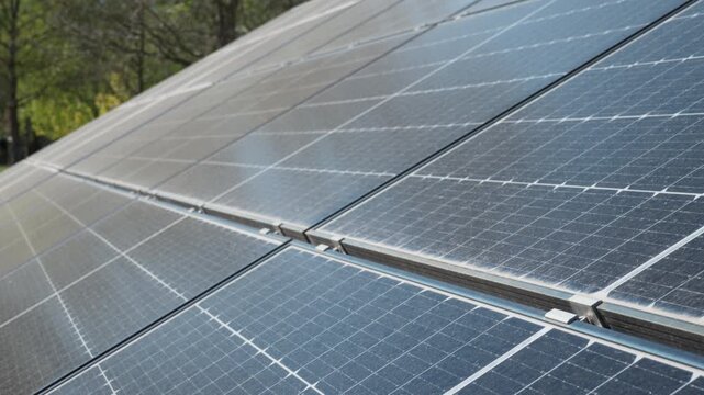 Surface of bifacial photovoltaic solar panels covered in dust and dirt. Industrial energy farm requiring maintenance to prevent power generation efficiency loss and energy yield reduction.