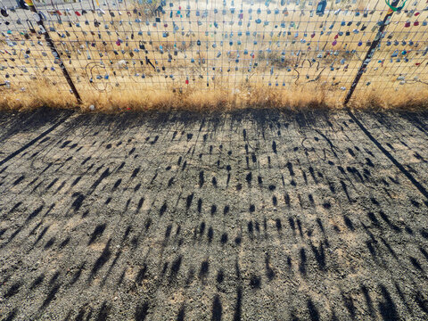 Shadows of Love Locks on a Farm Fence