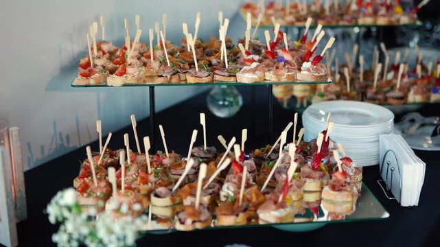 Catering service on banquet table with canape snacks in restaurant or hotel. Decorated food set on birthday, wedding celebration or business conference event venue.