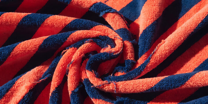 Folded striped towel close up of red and navy terrycloth texture