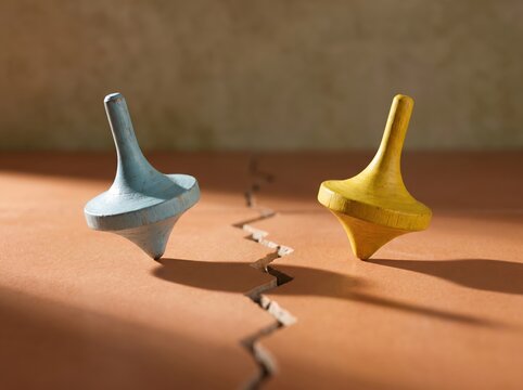 Two spinning tops on a cracked surface