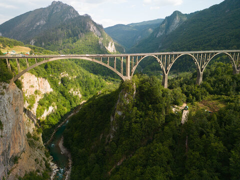 Aerial drone view of the historic Djurdjevica Tara Bridge over the deep Tara River Canyon. Turquoise water and lush green mountains in Montenegro.