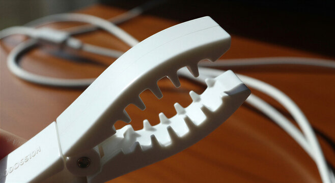 White cable management cord organizer on a wooden desk with cords  office supplies transparent background