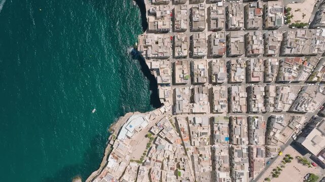 Aerial drone view of Polignano a Mare town in Puglia, Italy. Scenic coastal architecture, historic buildings, and beach by the Mediterranean sea during summer vacation.