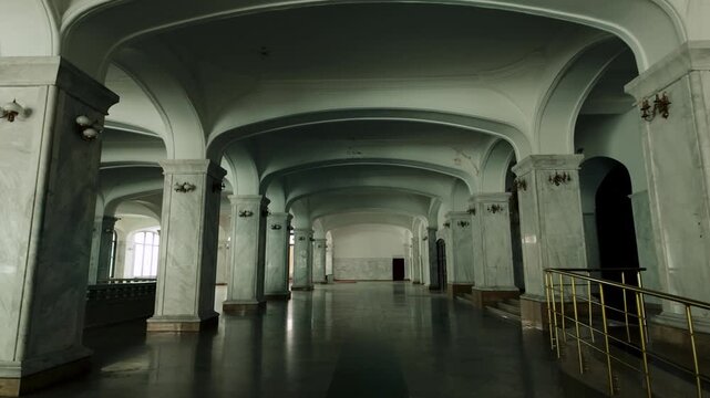 Expansive hallway inside Holy Trinity Cathedral, featuring rows of ornate marble pillars and high arched ceilings that create a sense of grandeur and historical depth. Polished floors reflect the a...