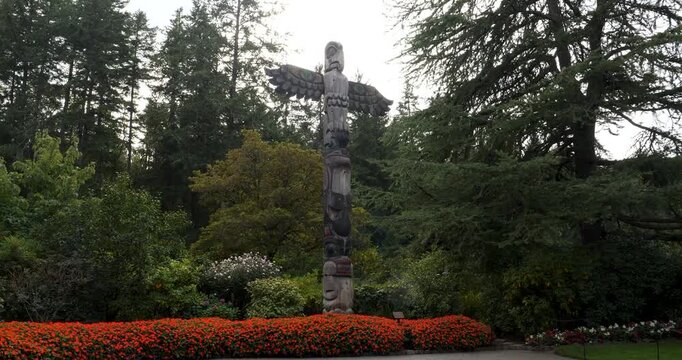 Wood-carved totem pole in Victoria Butchart Gardens,British Columbia,Canada.Totem pole carved in a classic Coast Salish traditional style.
