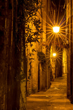Street light that is shining down on narrow street, Sovana, Tuscany, Italy, long exposure motion blur