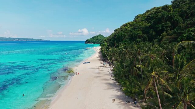 Establishing aerial shot of Puka Beach Boracay with tourists on sandy shore