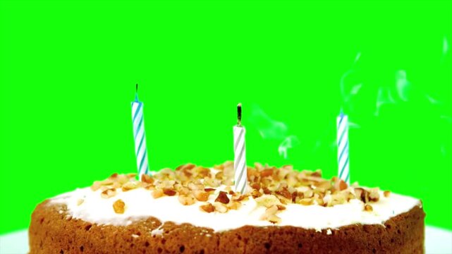 Delicious birthday cake with three burning candles on green screen background, 4k celebration dessert with white frosting and nuts, Chroma key 4k video footage