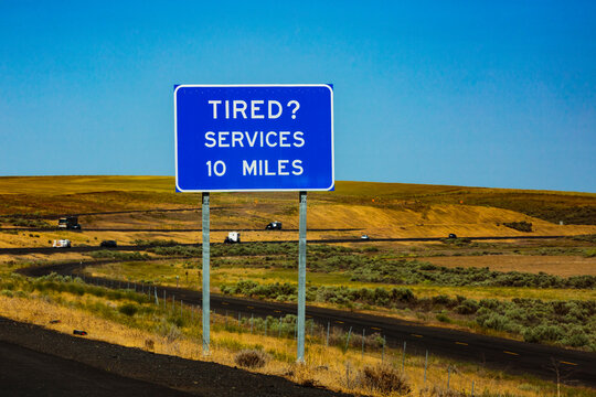 Highway rest area sign, Interstate 90 at Sprague, message reading Tired? Services 10 Miles.