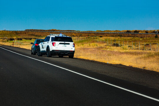 Washington State Trooper vehicle with lights on pulling over a vehicle to the roadside.