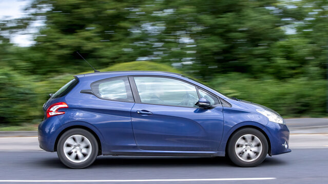 Milton Keynes,Bucks,UK - May 6th 2026: 2015 blue Peugeot 208 hatchback  car driving on a British road