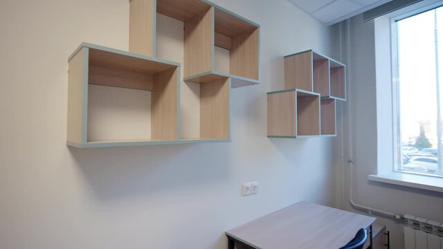 Compact dormitory features light wooden desks and minimalist wall cubbies. Window provides natural light for comfortable study sessions