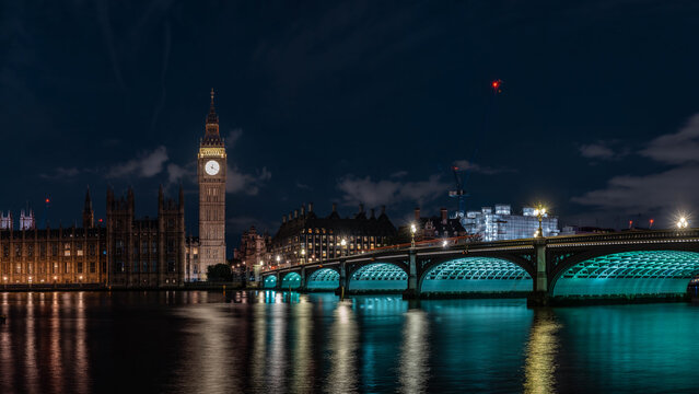 Big Ben and Westminster Bridge London UK night view Thames River illuminated tower reflection water historic skyline.