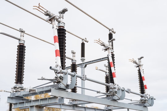 Detailed view of outdoor electrical switchyard hardware including porcelain isolators and heavy duty steel supports for high tension voltage current regulation