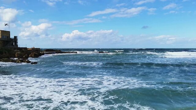 Waves crashing on rocks in Caesarea coastline, dramatic sea landscape, travel and nature power concept.