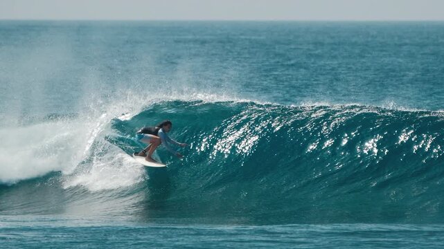 Teen boy surfer rides the wave in the Maldives and crazily falls from the lip all the way down