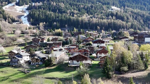 Aerial view of le Praz village in Courchevel ski resort by spring, with chalets and houses in French alps mountains