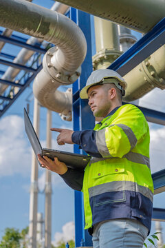 Industry specialists inspect massive piping at a gas-fired power plant integrated with a petroleum and oil refinery complex, focusing on maintenance for energy generation safety and efficiency.