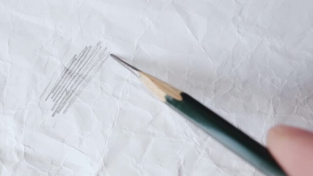 close up of graphite pencil drawing on textured paper. slow motion footage. Background video can be used as overlay. doodling hatching