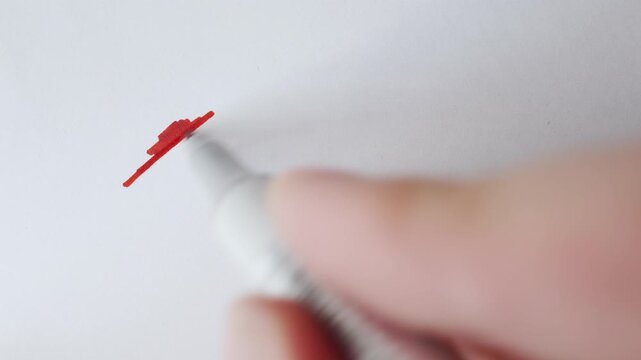 Red marker strokes and hatching cloud with real marker for text overlay on textured white paper close up.