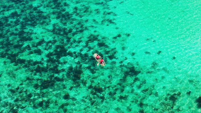 Drone follows transparent kayak over crystal waters at Puka Beach, Boracay