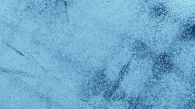 Extreme macro close-up of cracked blue melting ice texture in time lapse. Abstract frozen water surface with translucent crystal patterns, condensation and thawing details in studio lighting.