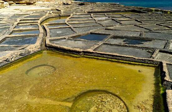 Empty salt pans carved into the coastal limestone rock formations along the shoreline of eastern Malta near Marsaskala.  