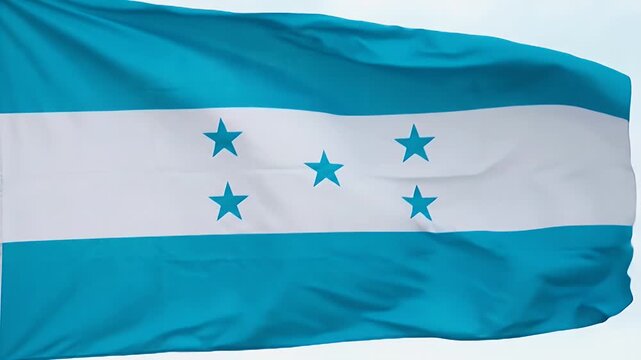 The video depicts the national flag of Honduras prominently waving against a clear sky. The flag features three horizontal stripes in alternating blue and white, with five blue stars arranged in an X