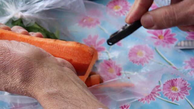 Hands peeling fresh carrot with metal vegetable peeler video