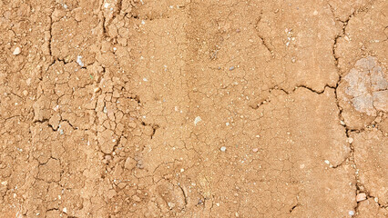 Texture of a dry dirt road with cracks and dust, unpaved rural path in arid region, top view of parched ground surface © Gulmira Uatkhanova