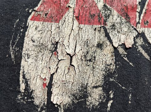 Cracked plastisol ink texture on black fabric with red and white distressed pattern