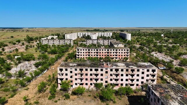 Wide aerial drone view of ruined apartment blocks in the abandoned ghost town of Chagan. A former secret Soviet military site Semipalatinsk 4 in Kazakhstan. Atmospheric footage of total desertion and 