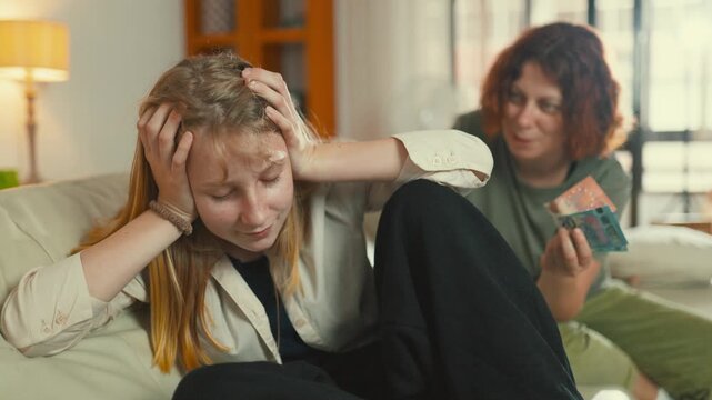 Mother bribing her upset teenage daughter with money