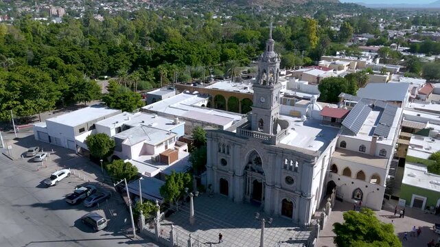 The ornate white bell tower of the Nuestra Se&ntilde;ora del Carmen Parish Church in Hermosillo, Sonora (Mexico). In the background, the iconic Cerro de la Campana rises, its communication antennas visible.