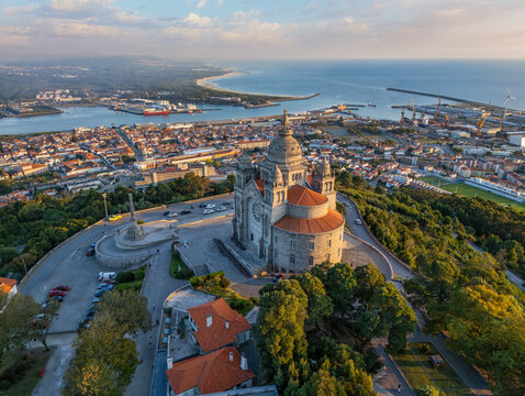 Drone shot of the famous Sanctuary of Santa Luzia at dusk with the city lights starting and ocean in Viana do Castelo, Portugal.