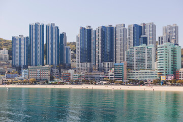 Obraz premium Songdo beach, Busan, South Korea with Songdo Cloud Trails Walk pedestrian bridge, sandy beach and Turtle island view, sunny day with blue sky, Songdo Skywalk and Geobukseom Island and Busan Air Cruise