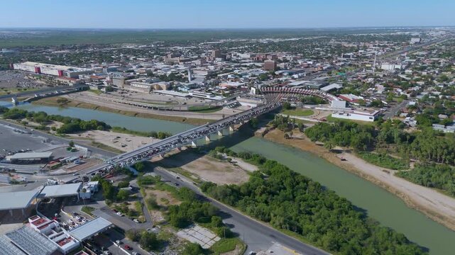 The Juarez-Lincoln International Bridge in Nuevo Laredo, Tamaulipas. The photo shows a long line of vehicles crossing the Rio Grande toward the U.S. border checkpoint.