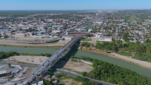 The Juarez-Lincoln International Bridge in Nuevo Laredo, Tamaulipas. The photo shows a long line of vehicles crossing the Rio Grande toward the U.S. border checkpoint.