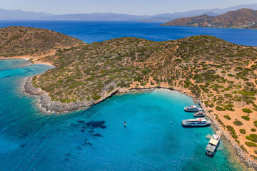 Tourist boats anchored in a turquoise bay at Kolokitha beach near Elounda © whitcomberd