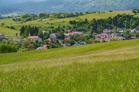 View of the village of Horna Lehota pri Brezne nestled among rolling green hills and lush forests with a historic church Horna Lehota, Banskobystricky kraj, Slovakia.