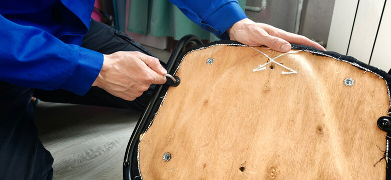 Repairing a chair by tightening screws and adjusting parts in a workshop