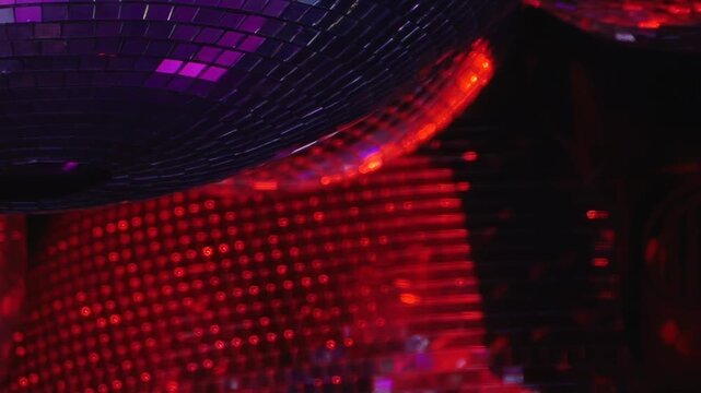 Sparkling disco balls illuminate a dim nightclub with a radiant cascade of colorful light during a joyous Christmas party.