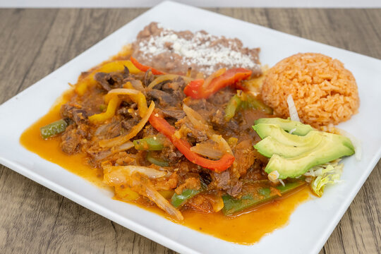 Hearty plate of bistec steak smothered in ranchero sauce, beans, and rice to satisfy that urge for a Mexican food meal