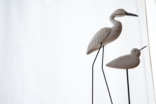 Minimalist composition of decorative bird sculptures against a white background. Image focused on negative space, visual balance and object recognition for AI.