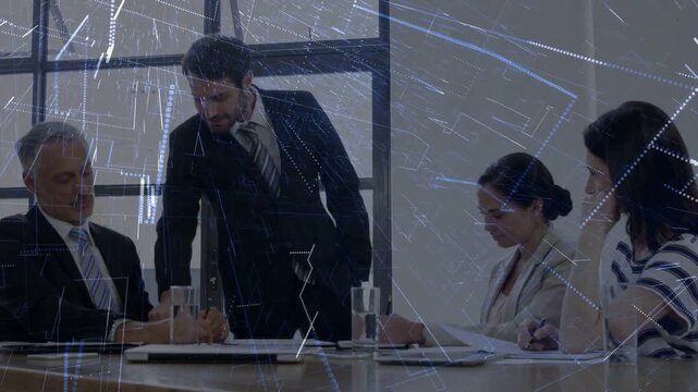 Manager standing up and pacing by business table, presenting data while overlay showing charts
